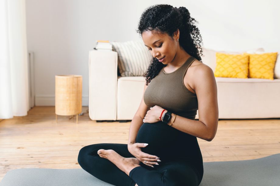 Pregnant woman holding belly and staring longingly at it