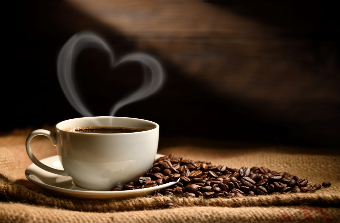 coffee mug with heart shaped steam tendrils, place in a bed of coffee beans
